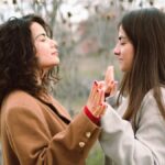 Two young women engage in a mindful meditation practice in a serene natural setting, fostering relaxation and connection.