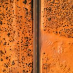 Stunning aerial view of a straight highway cutting through the barren Arizona desert landscape.