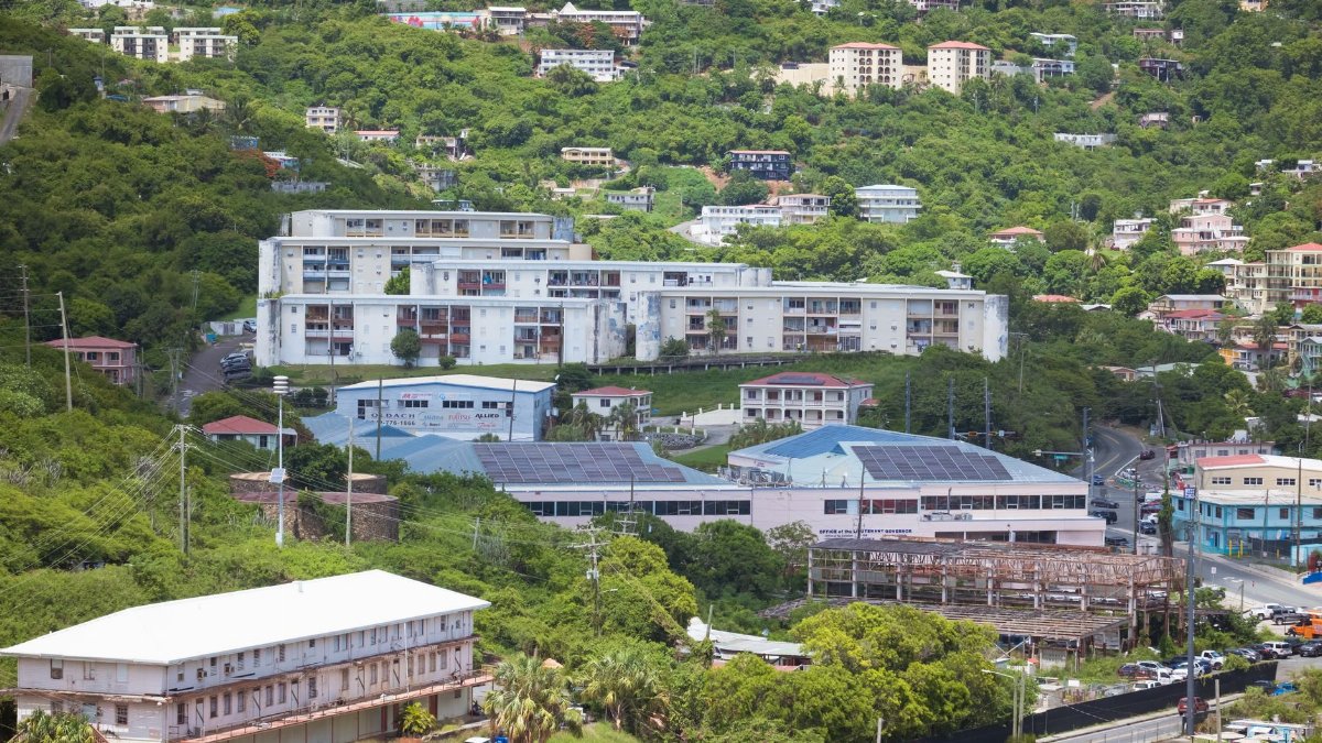 Aerial view showcasing buildings nestled in lush greenery, capturing urban life amidst nature.