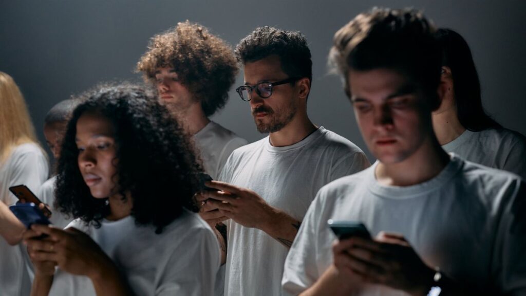 Group of young adults focused on their smartphones, embodying modern social technology and isolation.