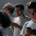 Group of young adults focused on their smartphones, embodying modern social technology and isolation.