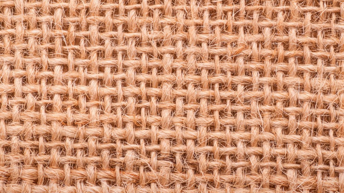 Close-up of a rough jute weave texture showing intricate fibrous pattern.