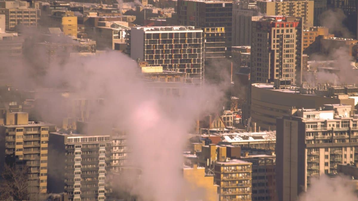 City skyline with smoke rising from buildings, showcasing urban winter scene in Montreal.