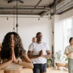 A multicultural group of adults practicing yoga poses together in a bright studio.