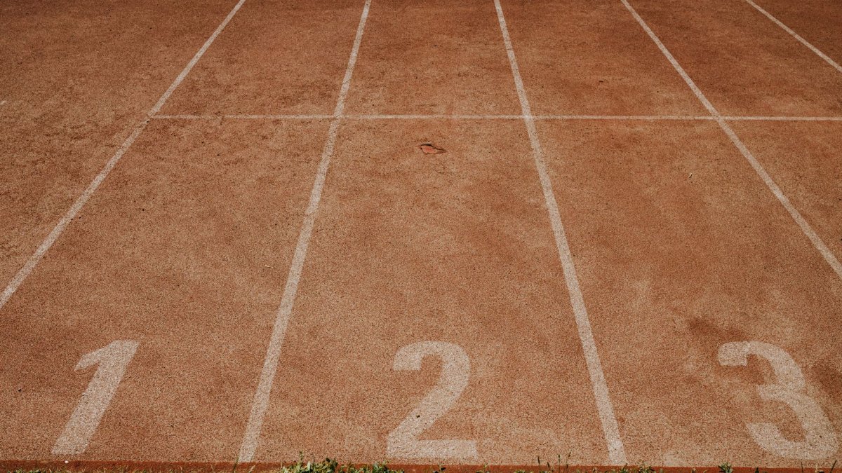Outdoor sports track with lanes numbered 1 to 3, ready for an athletic event.
