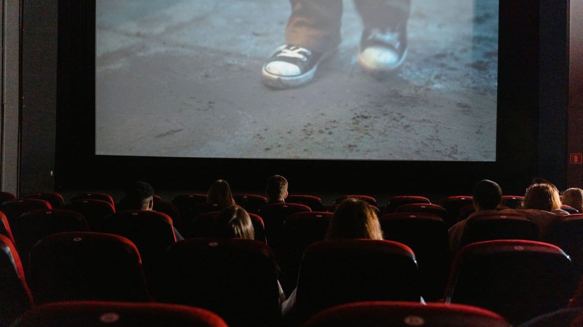 A group of people enjoying a film in a cinema with a large screen.