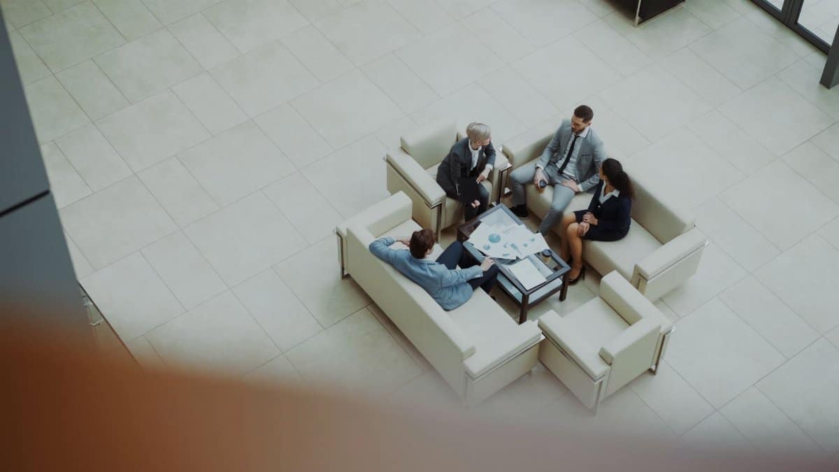 Business professionals in a meeting, viewed from above, in a modern office setting.