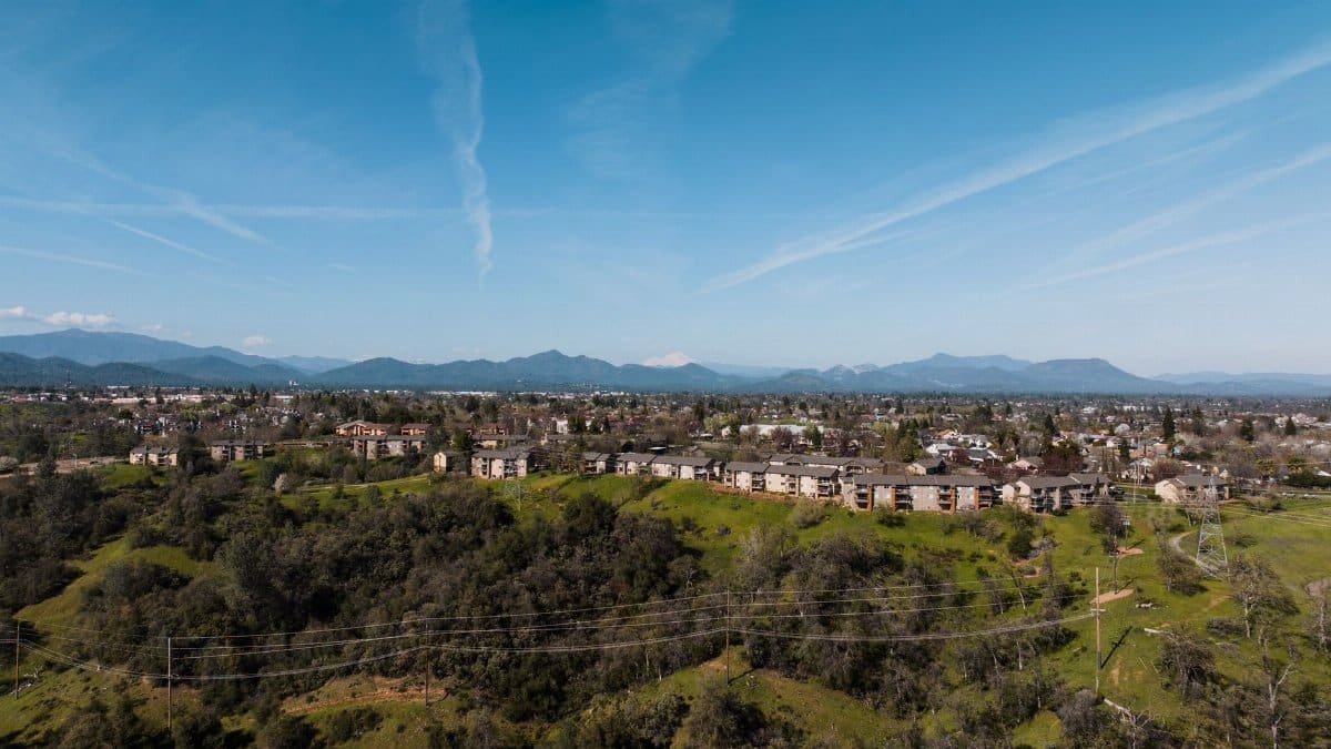 Aerial view of Redding, CA showing the townscape with clear skies and distant mountains.