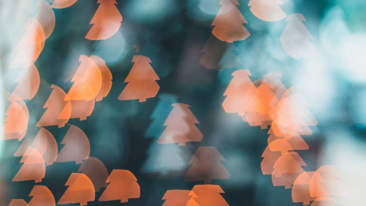 Festive abstract image with Christmas tree bokeh lights in warm tones.