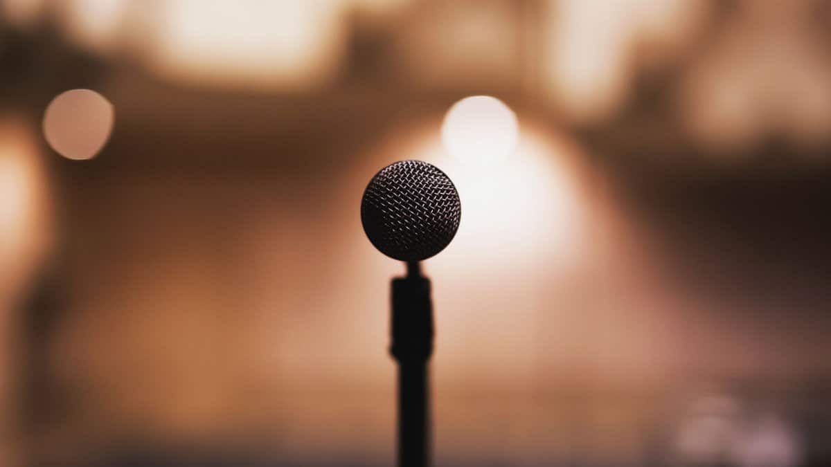 Microphone on stand with blurred background, ideal for music or speech themes.