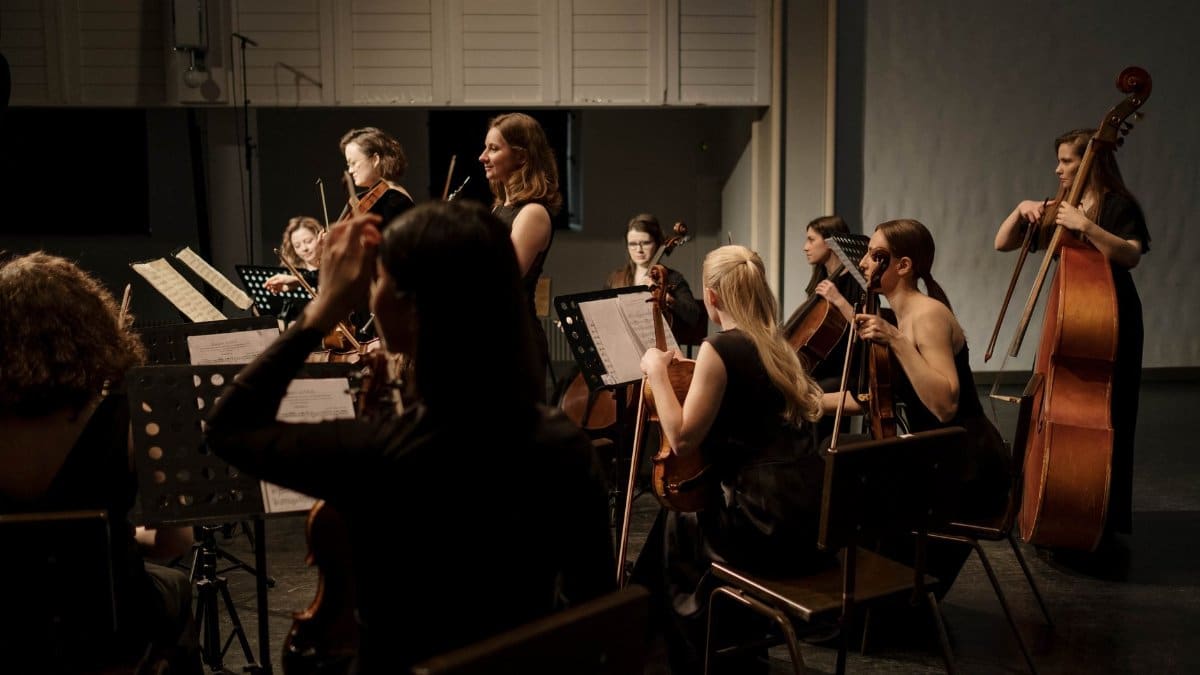 A group of professional musicians performing a classical symphony on stage.