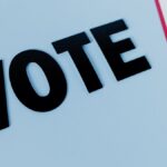 Close-up of the word 'VOTE' on a minimal background, emphasizing voting importance.