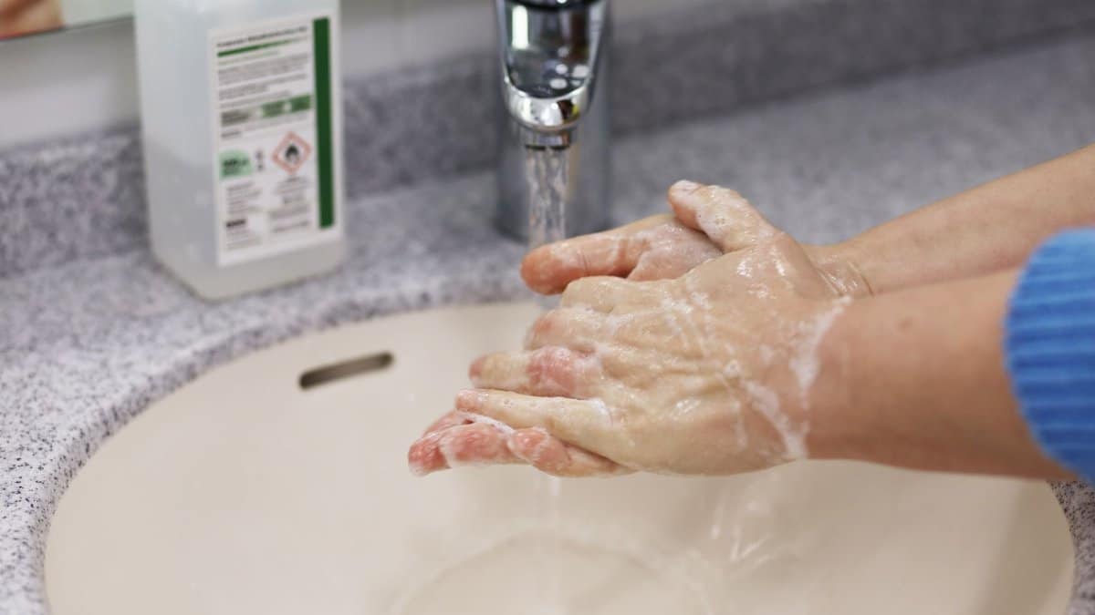 Close-up image of hands washing with soap in a bathroom sink promotes hygiene and cleanliness.