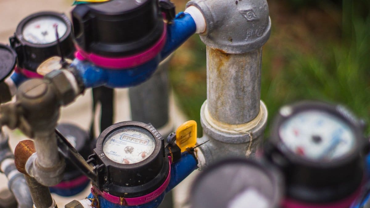 Detailed image of industrial water pressure gauges and pipes in an outdoor setting.