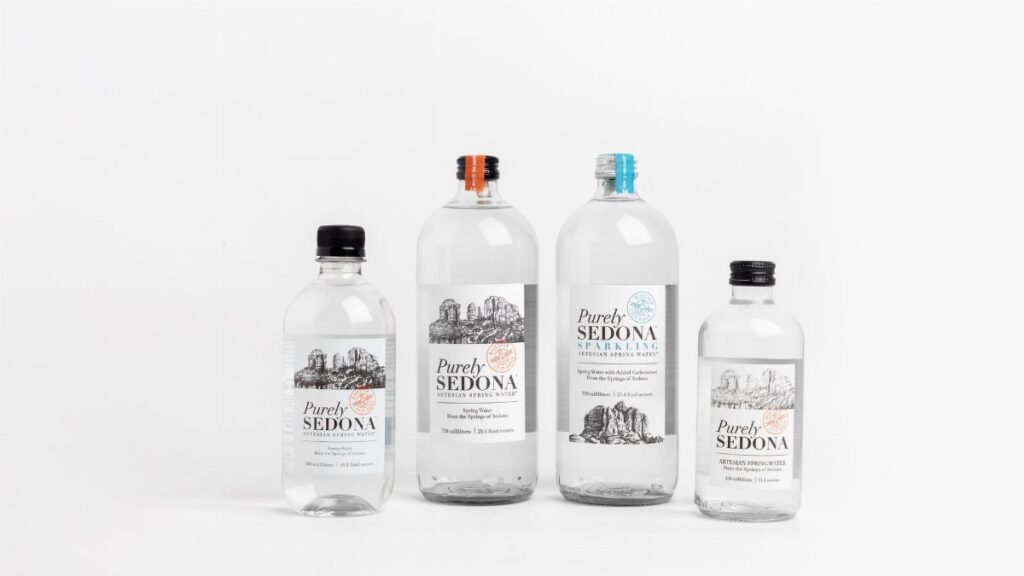 Studio shot of Purely Sedona water bottles in various sizes on a white background.