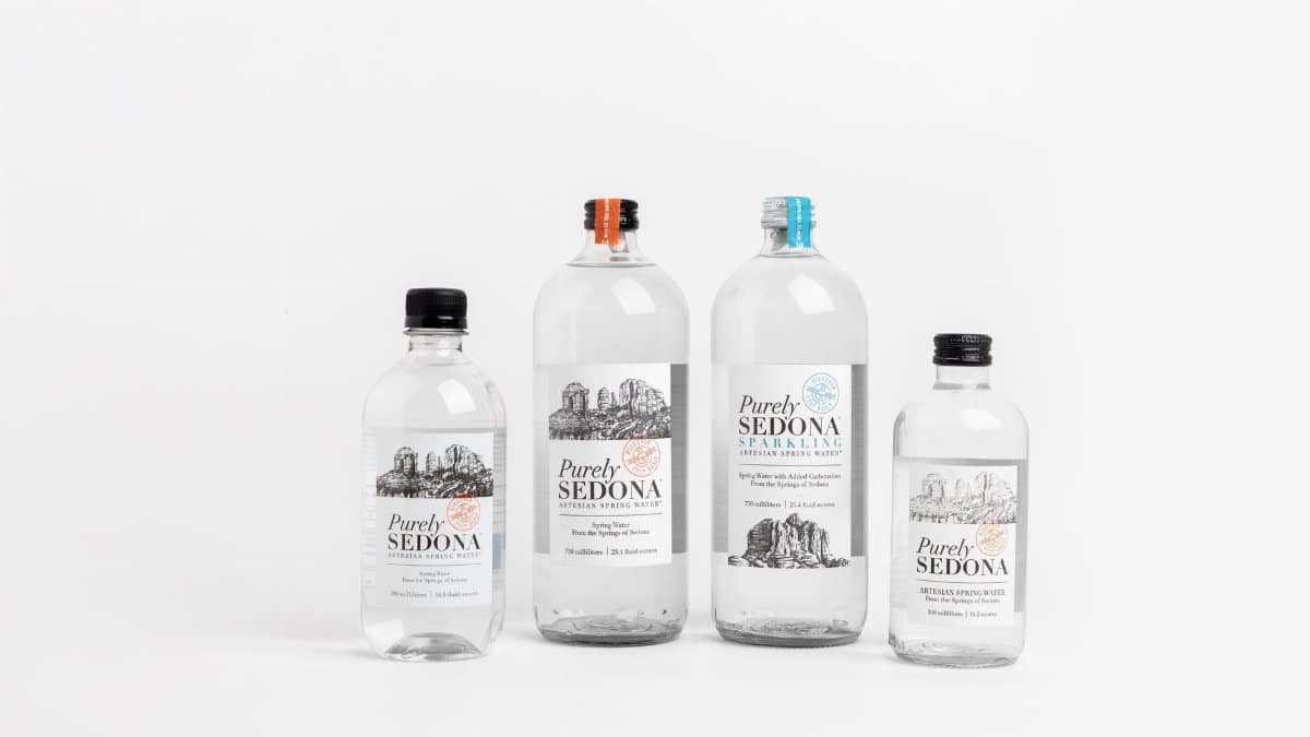 Studio shot of Purely Sedona water bottles in various sizes on a white background.