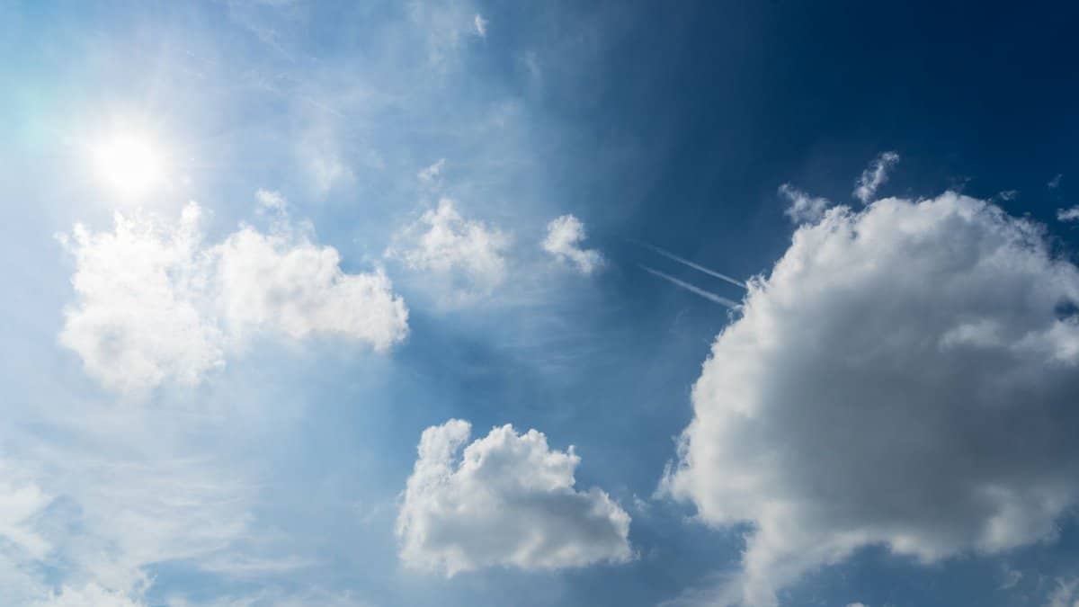 A serene view of fluffy white clouds against a bright blue sky, perfect for nature and weather-themed projects.