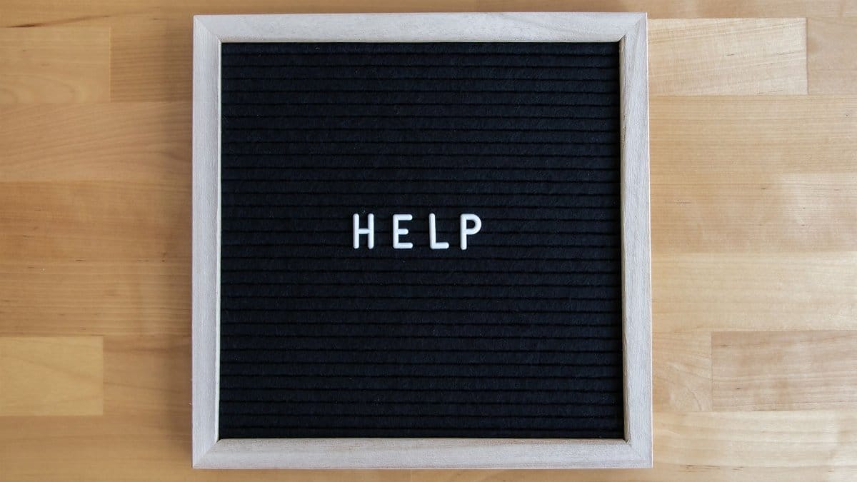 A letter board displaying the word HELP on a wooden surface, offering a minimalistic and modern look.