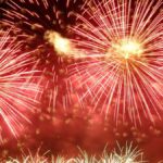 Vibrant red fireworks exploding in the night sky, creating a stunning visual spectacle.