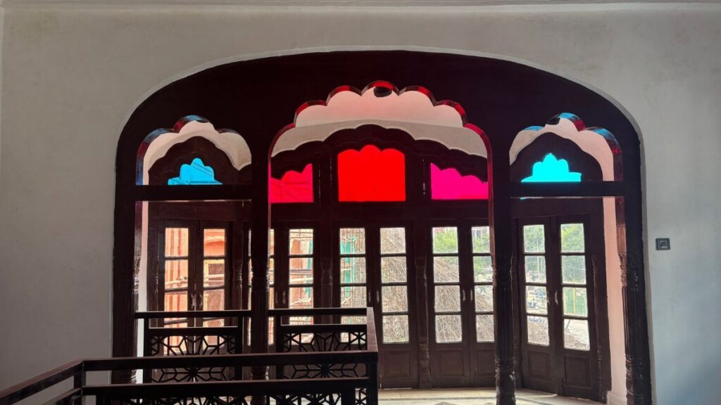 Decorative arched doors with vibrant stained glass in a historic building.