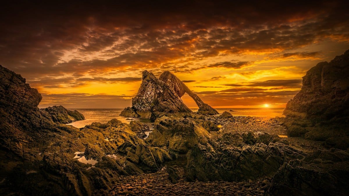 Discover the dramatic Bow Fiddle Rock at sunset along Cullen's scenic coastline.