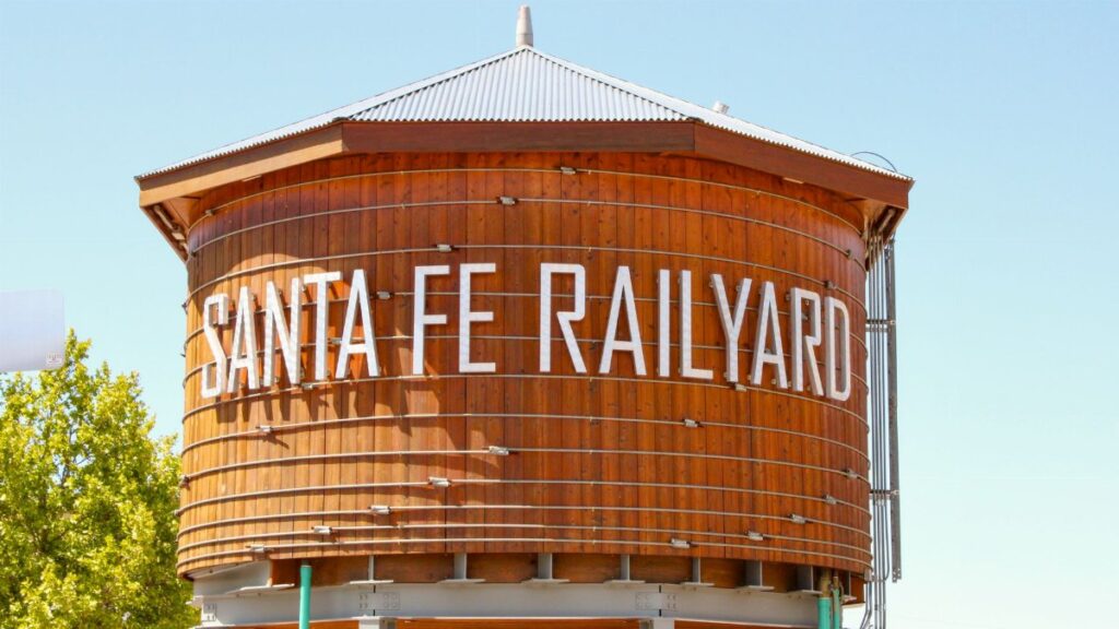 Iconic wooden water tower at Santa Fe Railyard, New Mexico, on a sunny day.