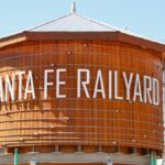 Iconic wooden water tower at Santa Fe Railyard, New Mexico, on a sunny day.