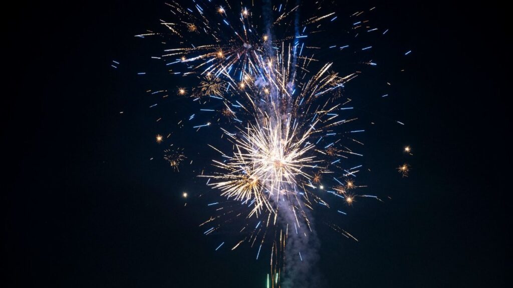 Vivid fireworks burst into colorful patterns against a clear night backdrop, creating a festive atmosphere.