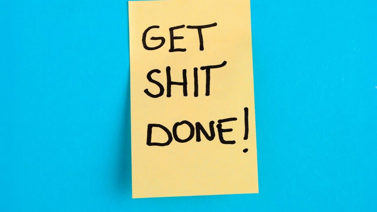 Yellow sticky note with motivational message on a bright blue background.