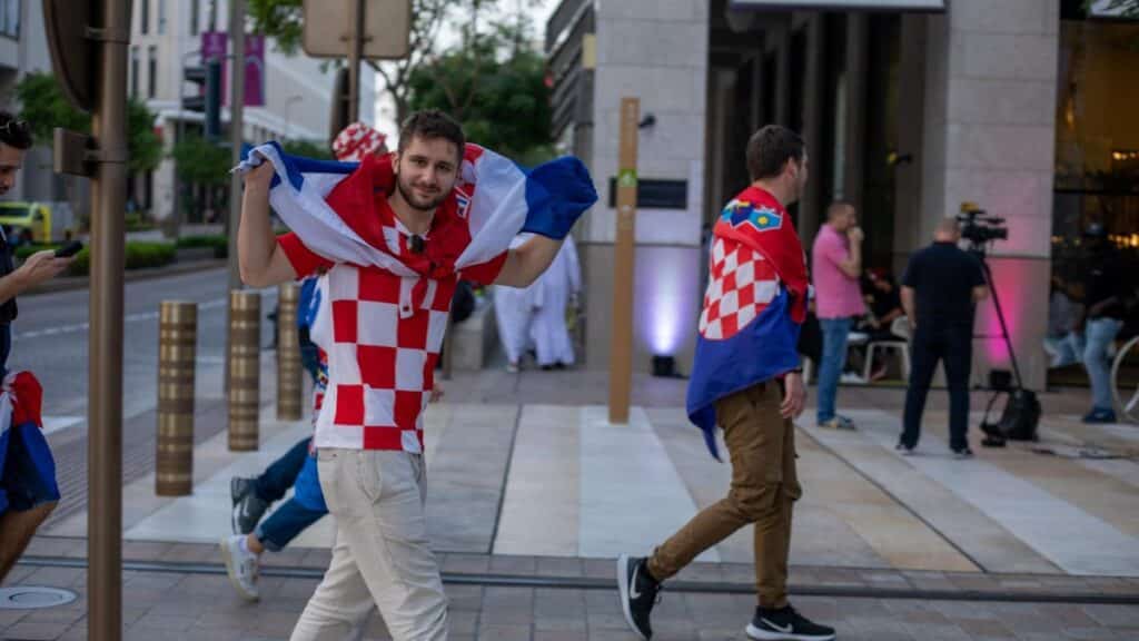 Croatian soccer fans celebrating with flags in the streets of Doha, Qatar during the World Cup.