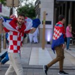 Croatian soccer fans celebrating with flags in the streets of Doha, Qatar during the World Cup.