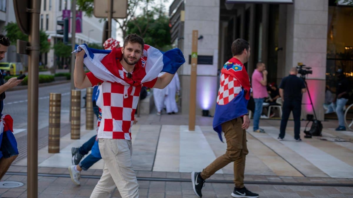 Croatian soccer fans celebrating with flags in the streets of Doha, Qatar during the World Cup.