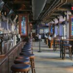 A spacious bar interior with wooden furnishings and colorful stained glass windows in Riverhead, NY.