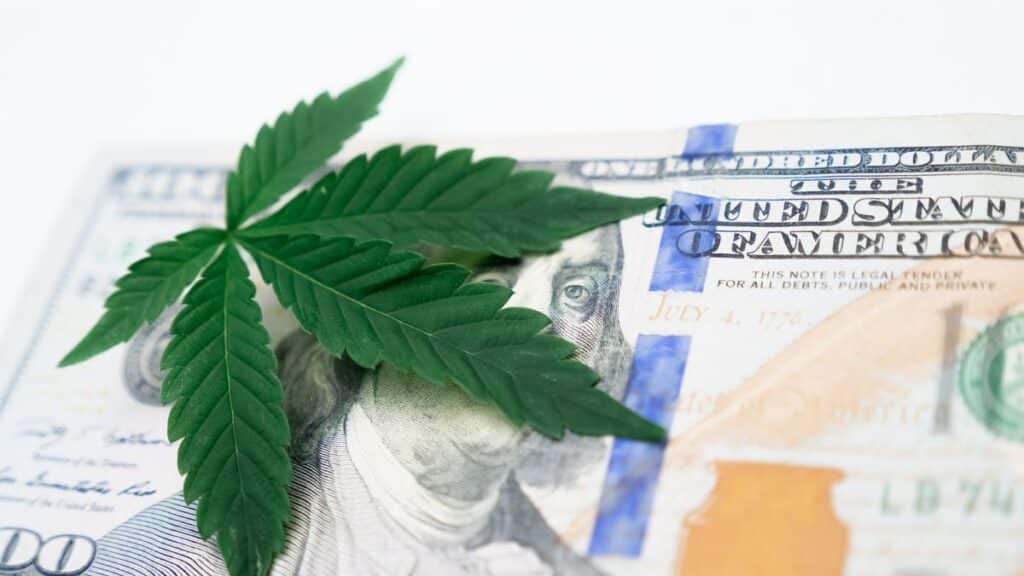 Cannabis leaf on a US hundred dollar bill symbolizing the marijuana economy.