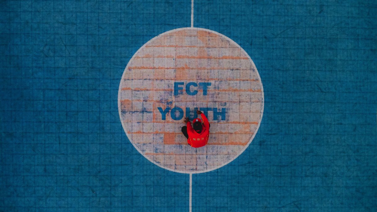 Drone shot of a person in red on FCT Youth sports court, Abuja, Nigeria.