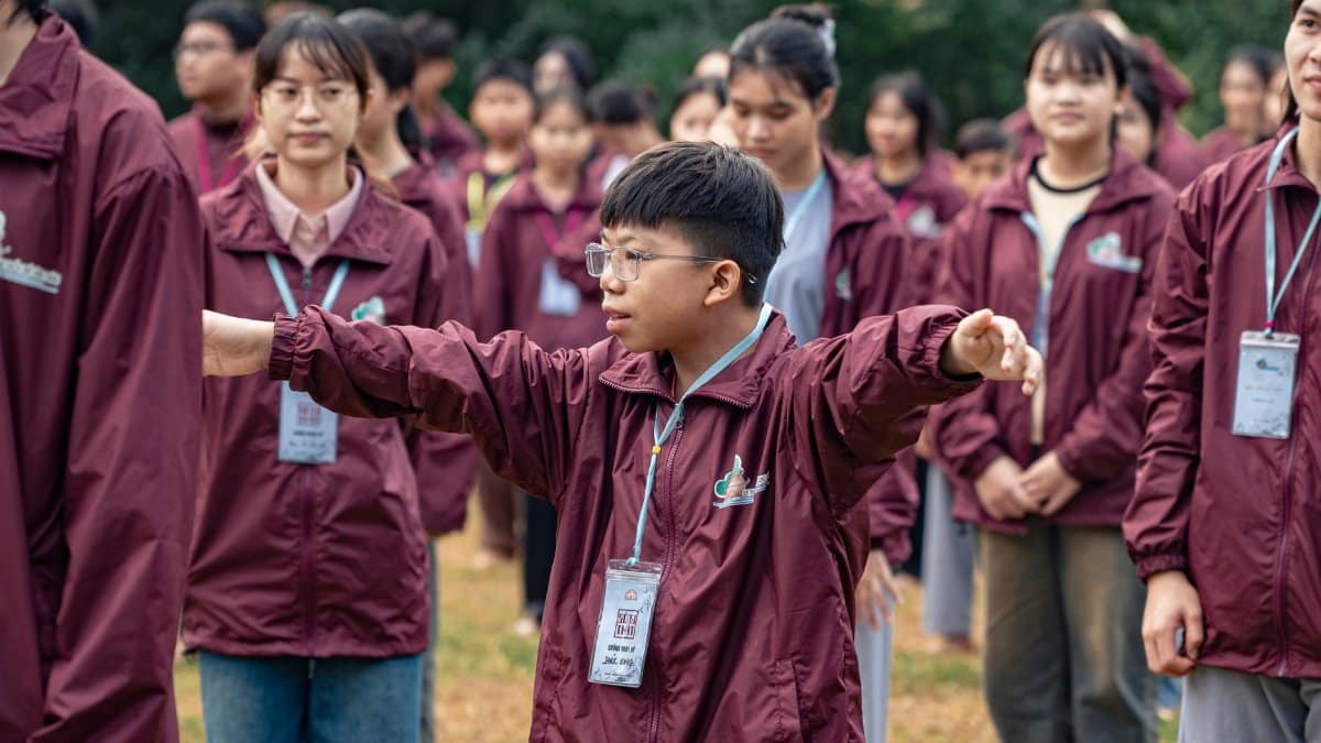 Teenagers engaging in a coordinated outdoor exercise in matching jackets.