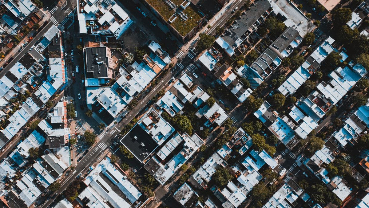 Aerial view of apartment houses located along straight asphalt roads in suburban district of city