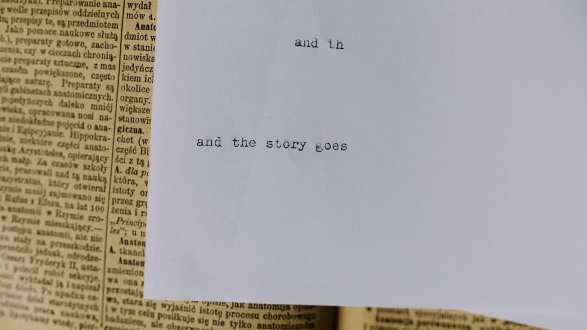 A piece of paper with typewritten text 'and the story goes' over an old book page.