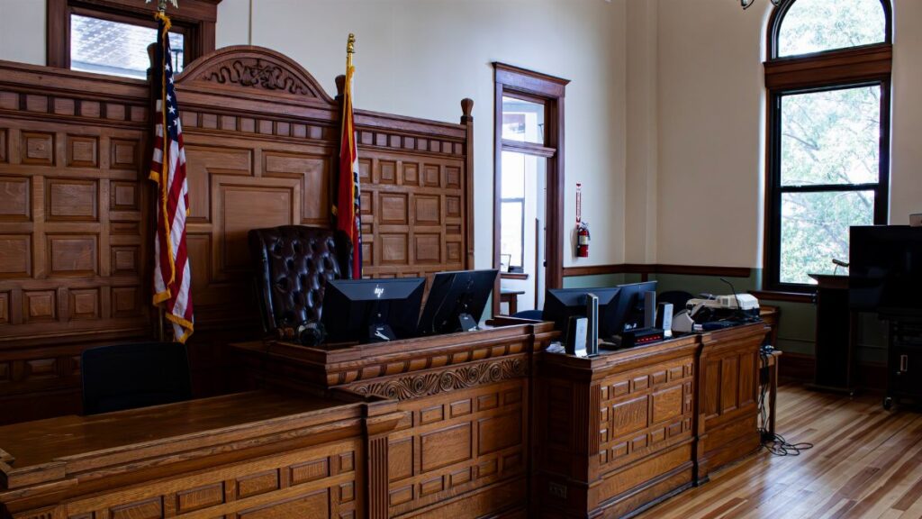 Interior view of an American courthouse in Kirksville, Missouri, featuring a judge's desk and flags.