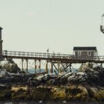 A scenic view of a lighthouse on rocky shores in Boston, MA.