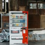 A vending machine stands in front of an eclectic wall with corrugated metal and old wood panels.