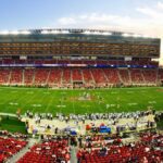 A stunning panoramic shot of Levi's Stadium in Santa Clara during a packed football game at sunset.