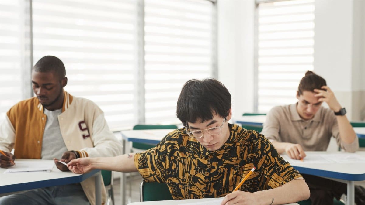 Students writing an exam with focus and diversity emphasizing education.