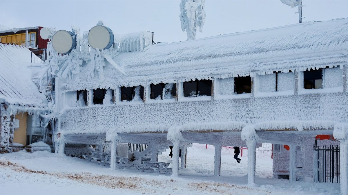 A frozen building covered in thick ice and snow, showcasing extreme winter conditions.
