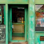 Bright facade of a New York pizza restaurant with neon signs and vintage accents.