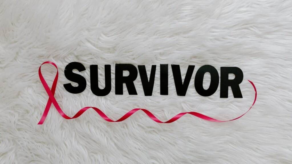 Inspirational image showcasing a pink ribbon next to SURVIVOR text on a soft white background.