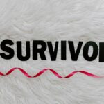 Inspirational image showcasing a pink ribbon next to SURVIVOR text on a soft white background.