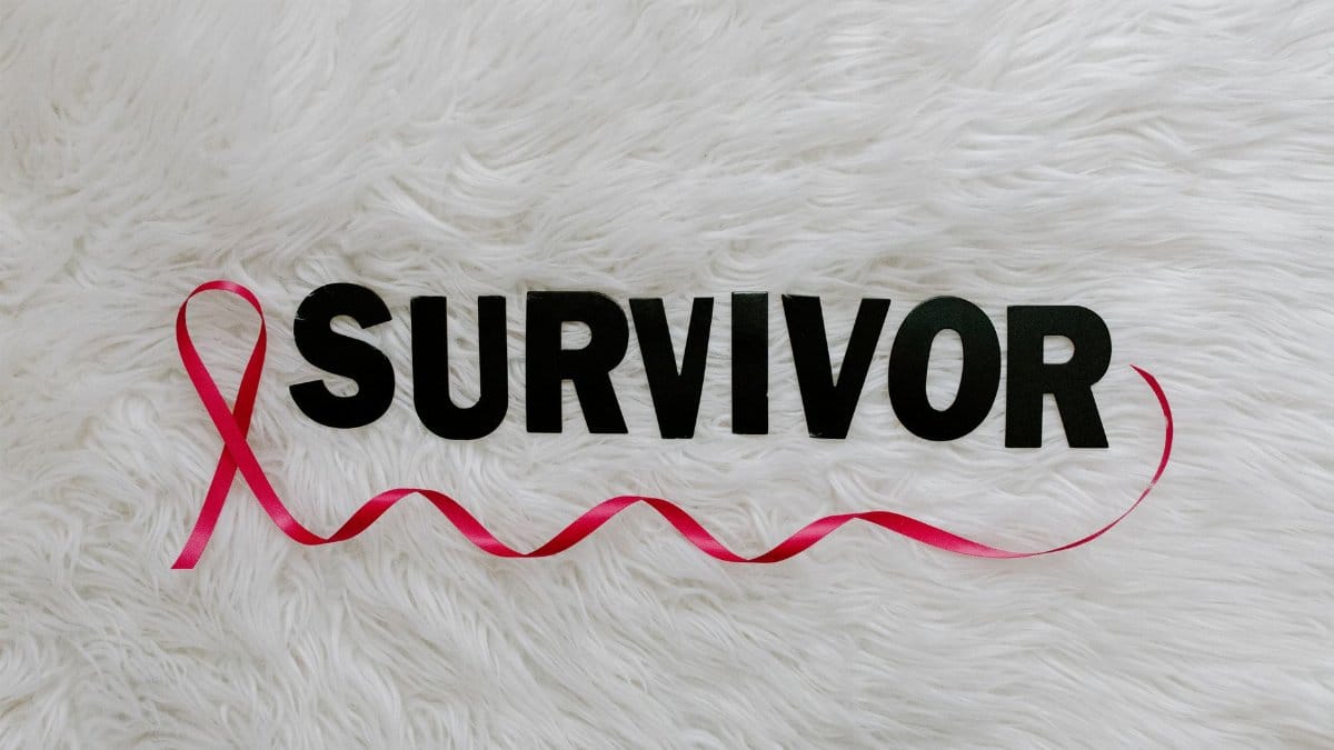 Inspirational image showcasing a pink ribbon next to SURVIVOR text on a soft white background.