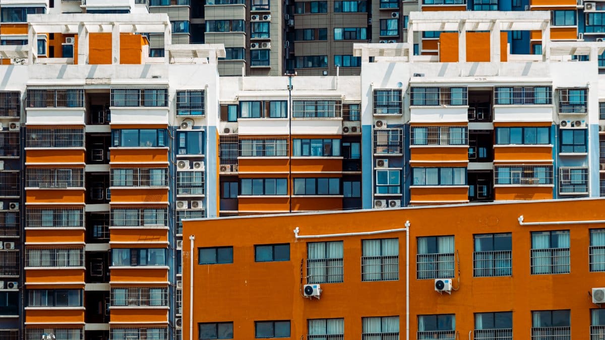 Close-up view of vibrant apartment facades with air conditioning units in a city setting.