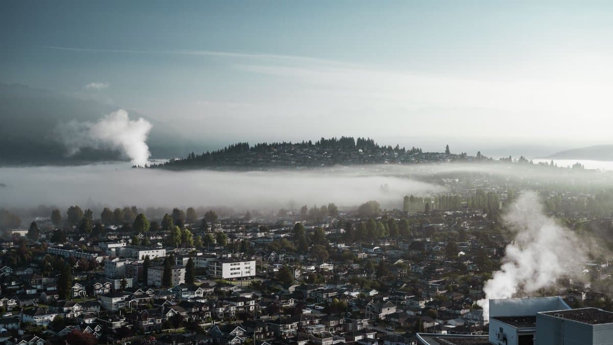 View of a cityscape enveloped in mist and smoke, highlighting urban pollution and environmental concerns.